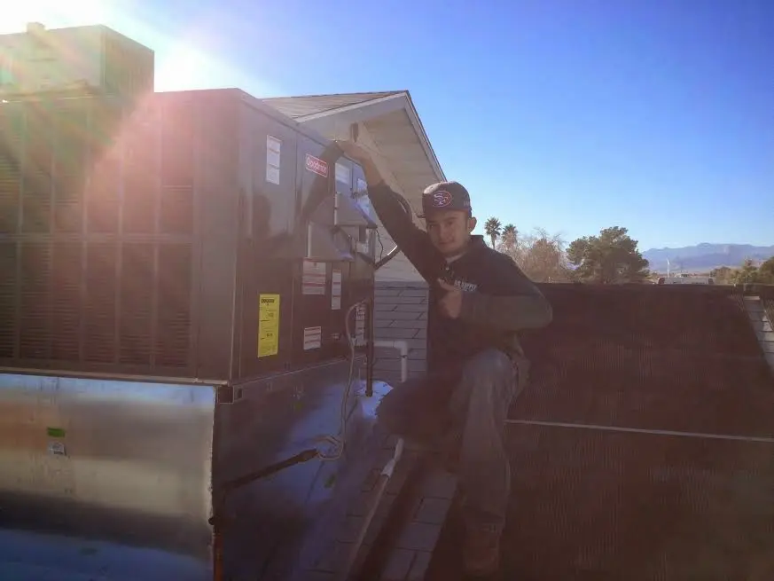 HVAC technician performing Air Duct Cleaning on a rooftop unit in Brownville